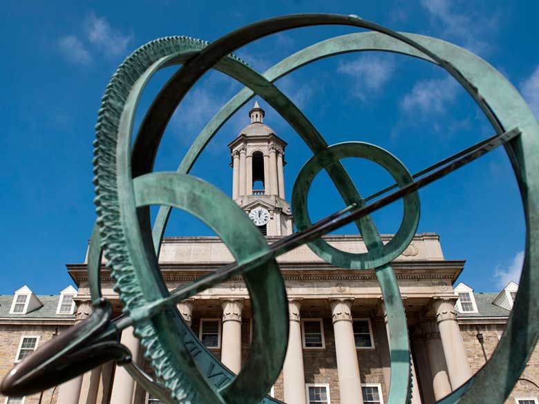 Peering through sundial on Old Main lawn at the tower clock