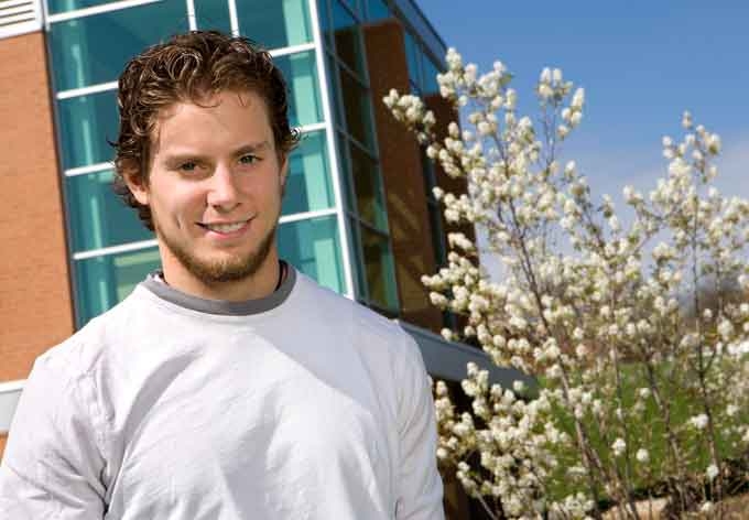 Male Penn State Beaver student poses in front of a building on campus.