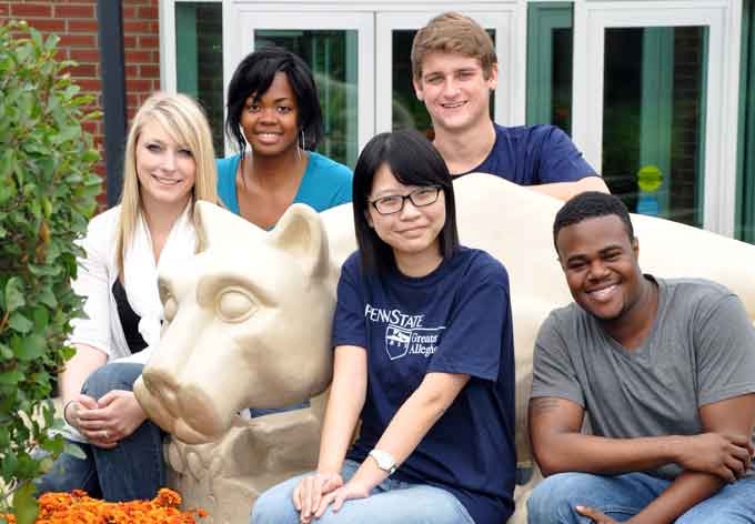 Photo of Penn State Greater Allegheny students posed on their Lion shrine statue, on the Greater Allegheny campus.