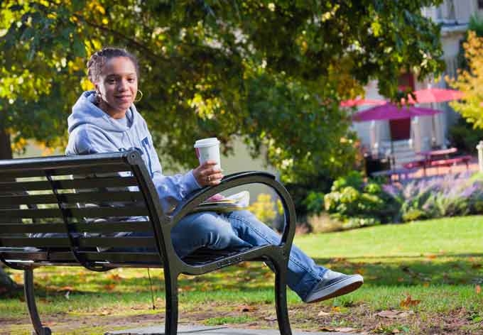 Penn State Mont Alto student relaxes on a park bench on the wooded campus in southcentral PA, home to one of the first forestry schools in the nation.